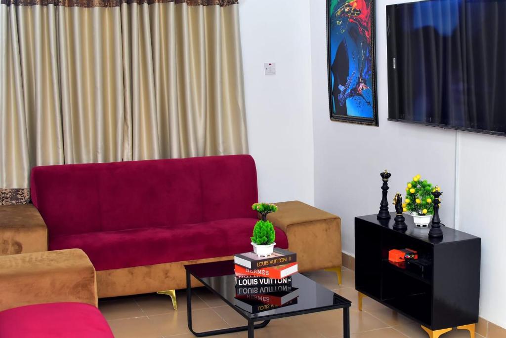 a living room with a red couch and a table at Hilltop Apartments in Mosan