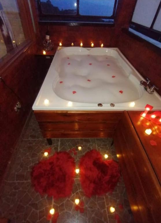 a bath tub with candles and red flowers in it at Alojamiento temático Rancho Texas in La Mesa