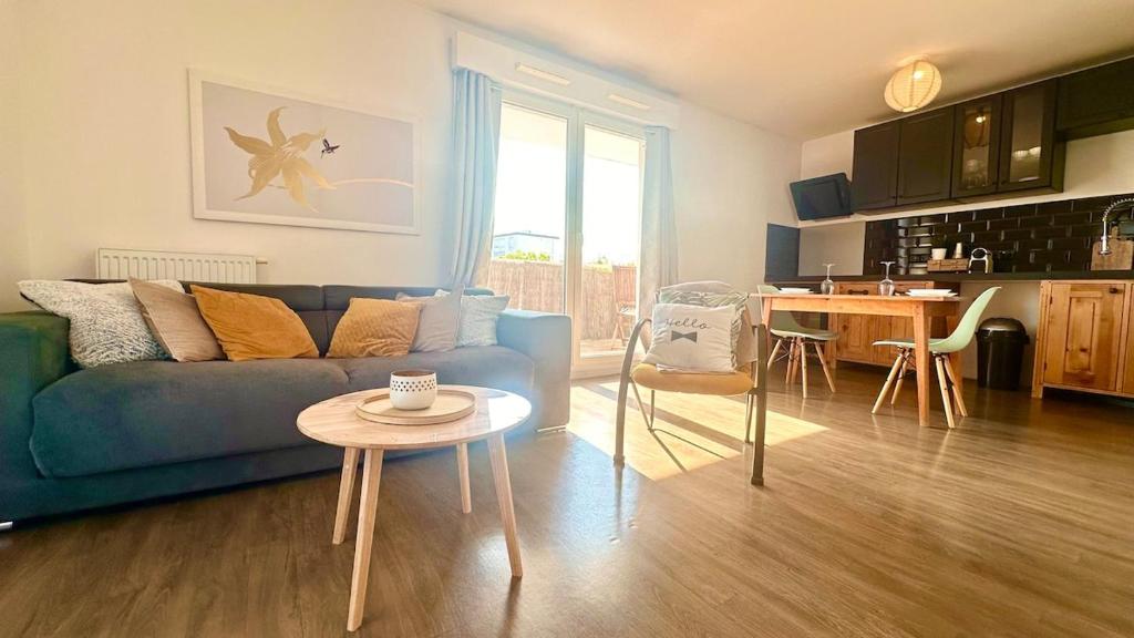 a living room with a blue couch and a table at Rotamagus Officiel in Rouen