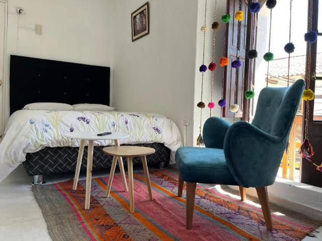 a bedroom with a bed and a chair and a table at Darios Hotel in Cusco