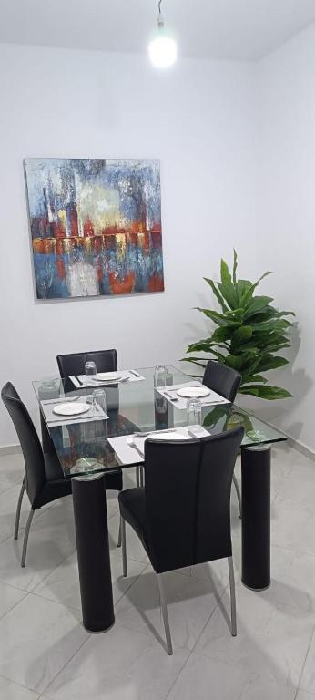 a dining room with a table and chairs and a painting at Maison céder in Azrou