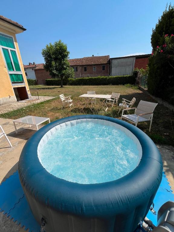 a large plunge pool in a yard with chairs at Casa Picarol Monferrato in Bergamasco
