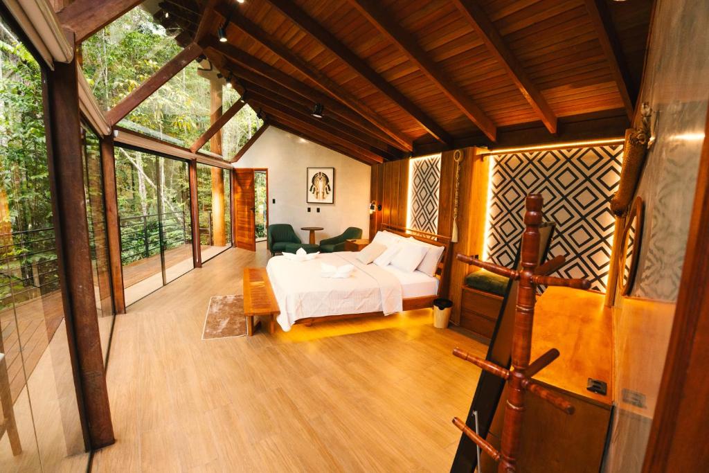 a bedroom with a bed in a room with windows at Cirandeira Amazon World EcoResort in Manacapuru