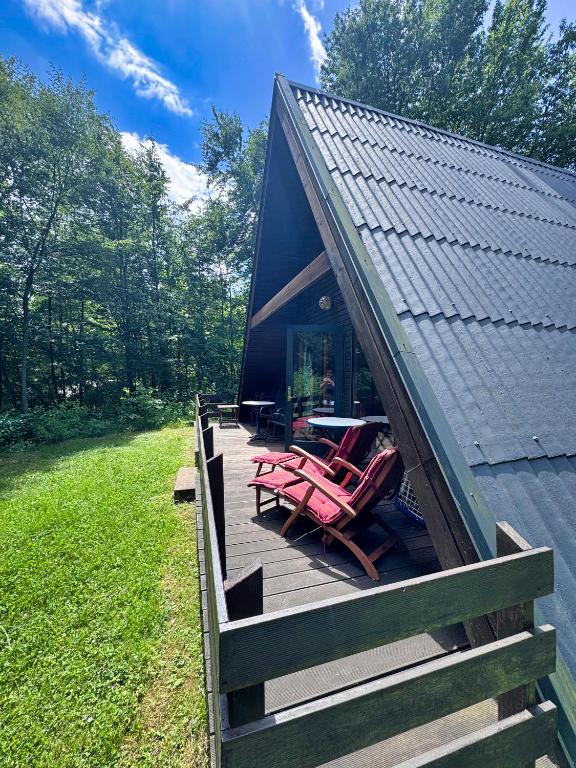 a house with a deck with chairs on it at Twiste Retreat 126 - Endreinigung und Handtücher pro Person inklusive in Bad Arolsen