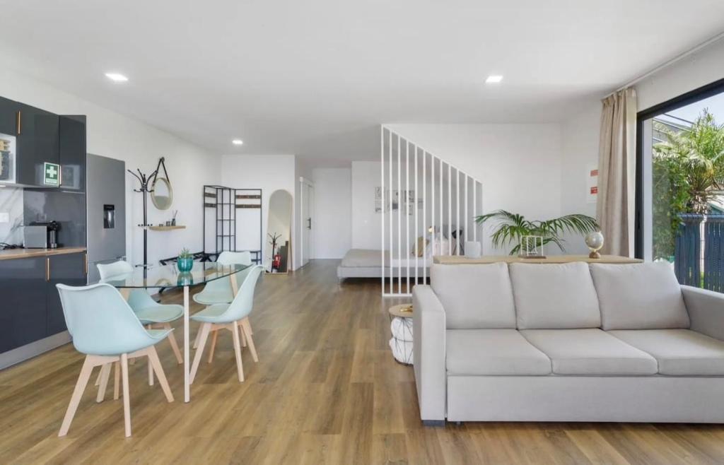 a living room with a white couch and a table at Modern Sea View Studio with Private Parking in Gaula