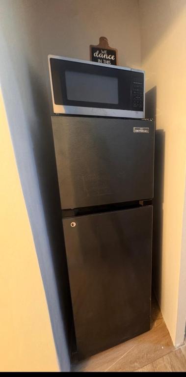 a microwave oven sitting on top of a refrigerator at Pearls and Palms Inn in Negril