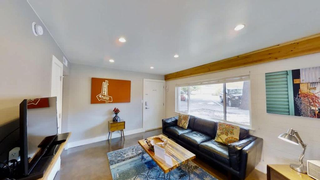 a living room with a leather couch and a tv at Moab Flats #3 in Moab