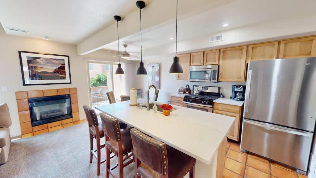 a kitchen with a refrigerator and a table with chairs at Henning's Escape #3328 in Moab