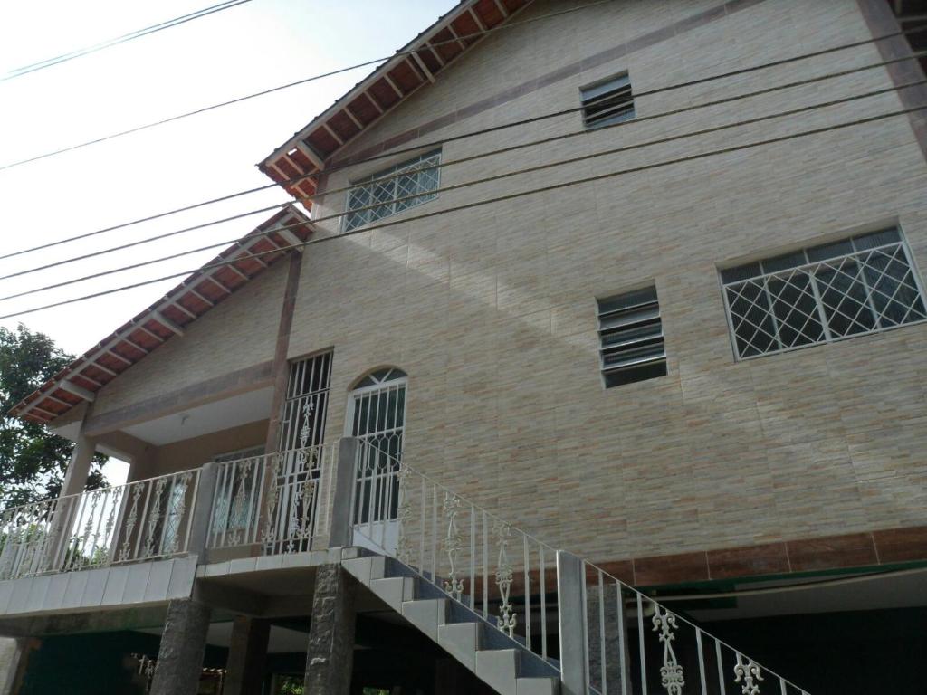 a house with a balcony on the side of it at Casas de Temporada Conservatória in Conservatória