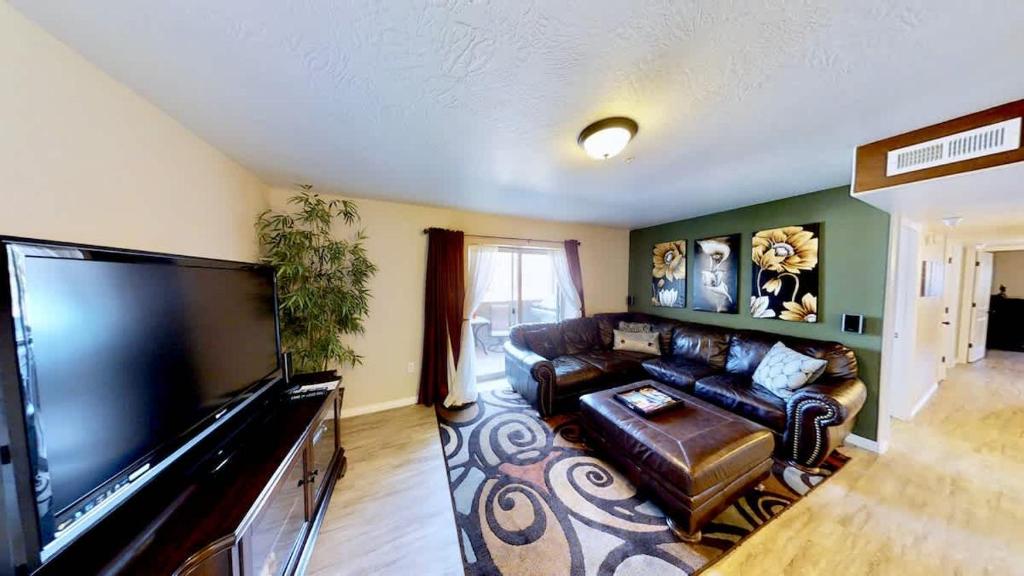 a living room with a couch and a large flat screen tv at Red Cliff Condos #1B in Moab