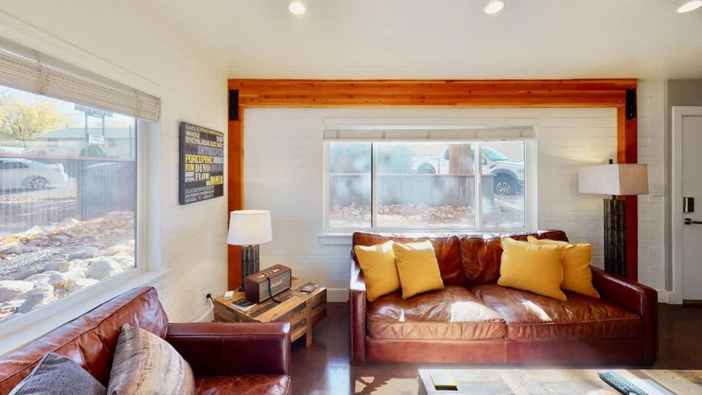 a living room with a leather couch and a window at Moab Flats #4 in Moab