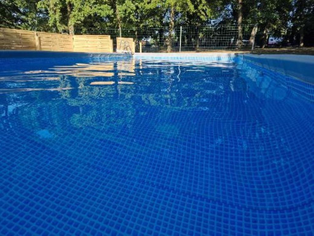 a large blue swimming pool with blue water at Camping Paus'Art Déco in Villemer