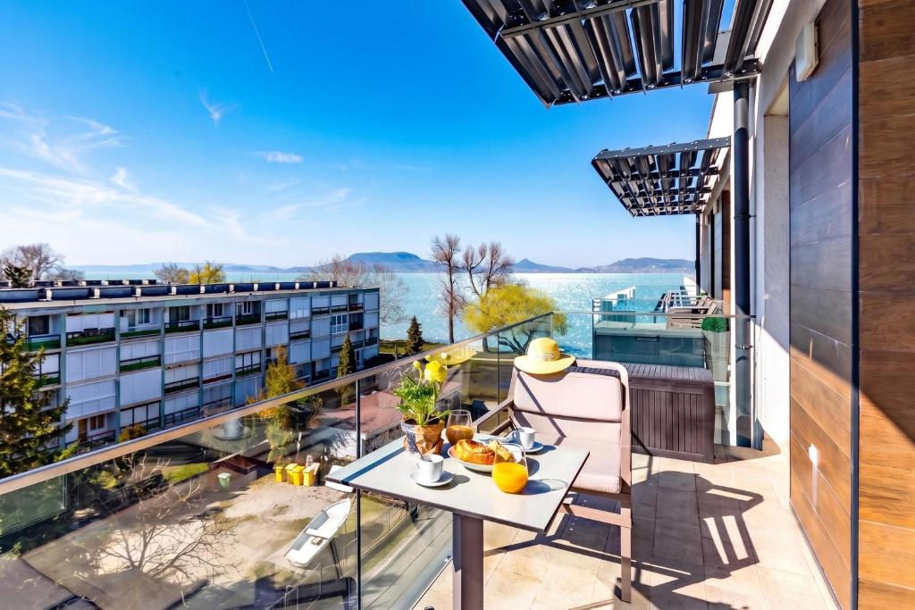 a balcony with a table and a view of the water at Sunset Resort 409 With Pool - Happy Rentals in Fonyód