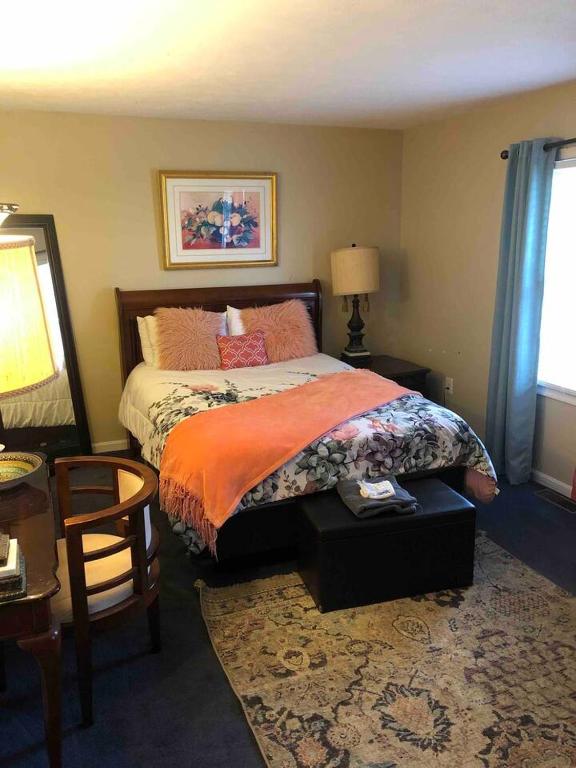 a bedroom with a bed and a table and a chair at The Haven at Charity House in Waldorf