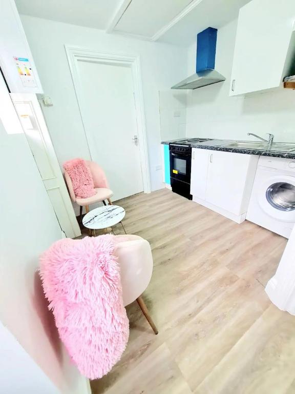 a living room with two chairs and a pink rug at Comfortable 2 Bed Apartment- Pass the Keys in Basildon