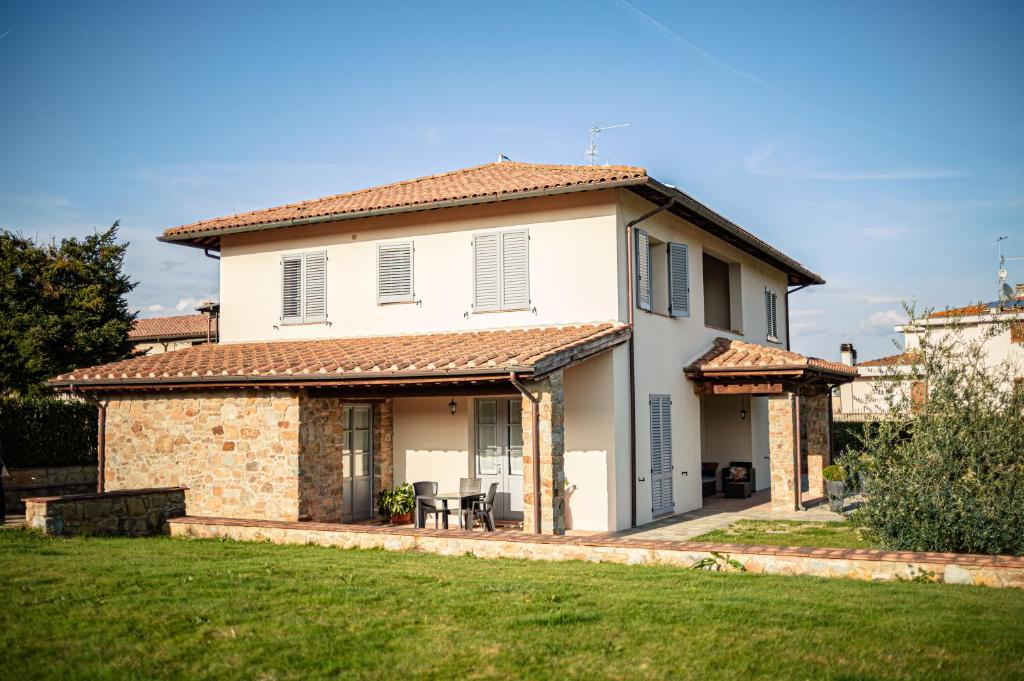 a large white house with a grass yard at Il Cerro in Arezzo