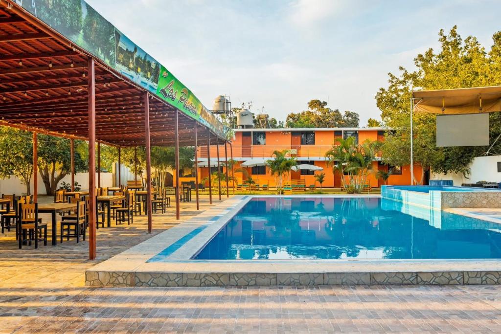 an outdoor patio with a pool and tables and chairs at Hospedaje Los Pecanos in Ica