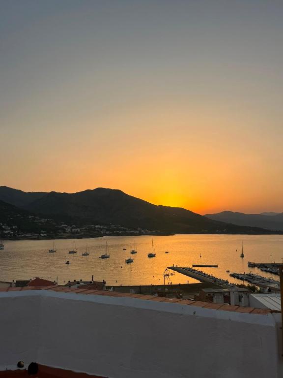 a sunset over a harbor with boats in the water at Hostal Boutique Es Grop in Port de la Selva
