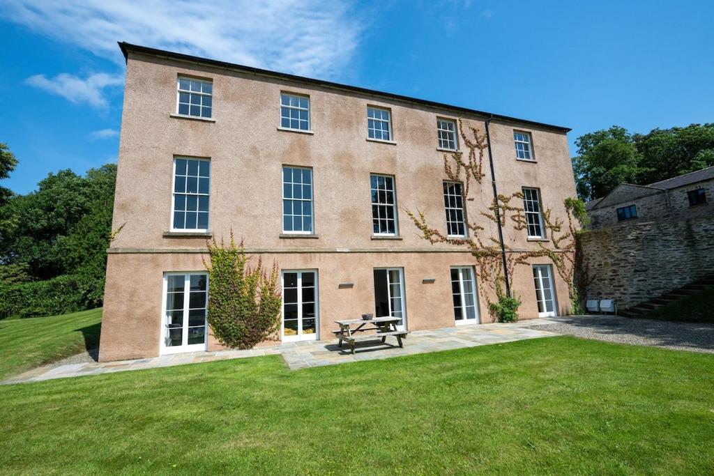 a large brick building with a picnic table in front of it at Glebe House in Sion Mills