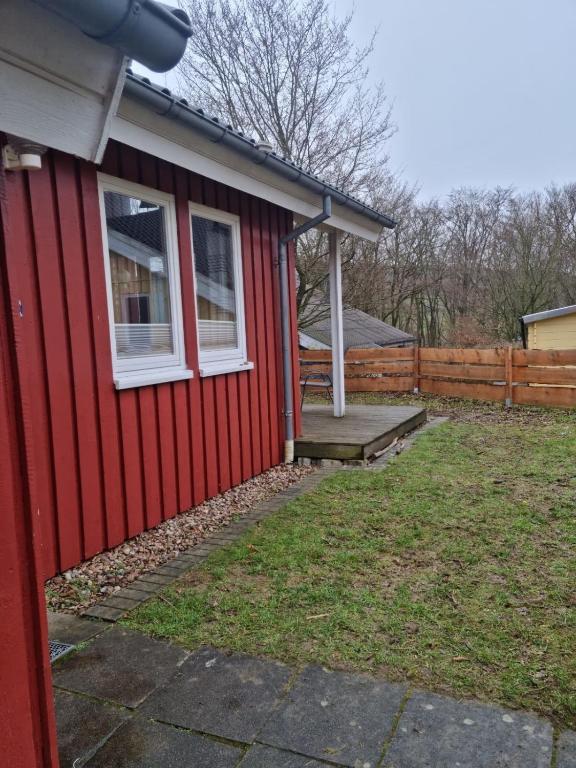 a red house with a white window and a porch at Ferienhaus Fuchsbau in Extertal