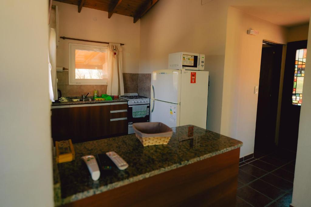 a kitchen with a white refrigerator and a counter top at Entre Campos in Los Reartes