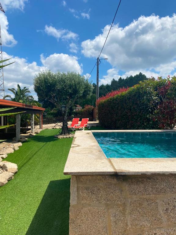 a swimming pool in a yard with green grass at Refúgio da Cancela - Arouca Stay in Arouca