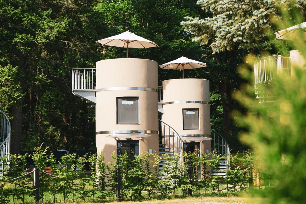 two white structures with umbrellas on top of them at slube am Krakower See in Krakow am See