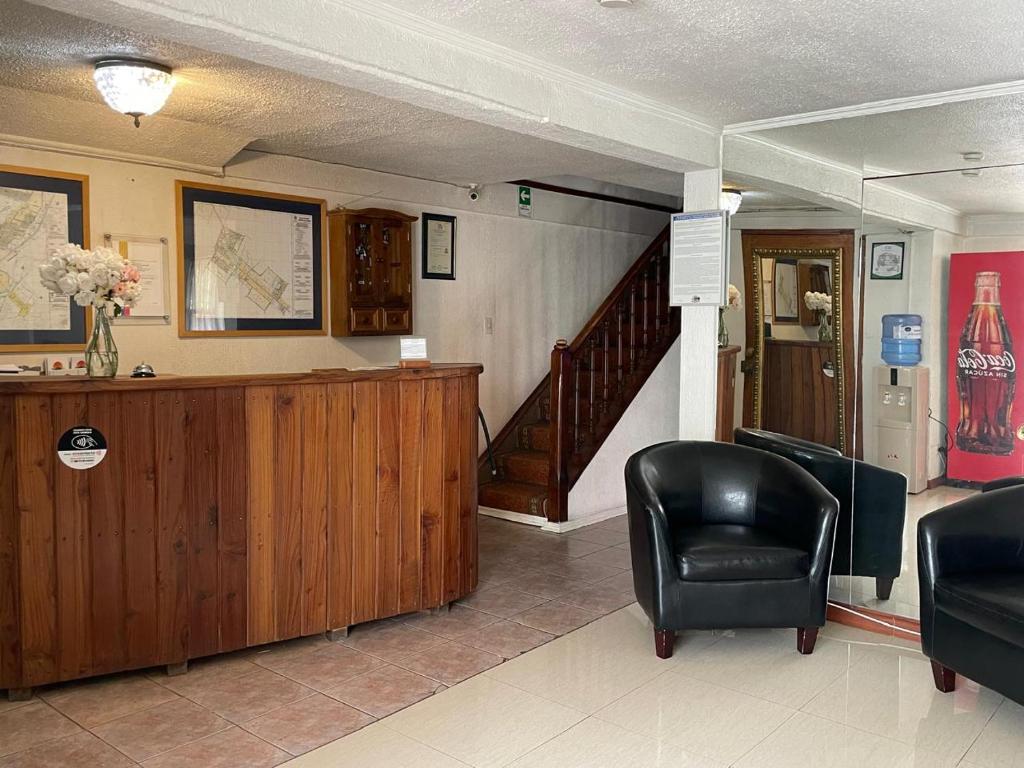a waiting room with a chair and a desk at Apart Hotel Punto Real in Curicó