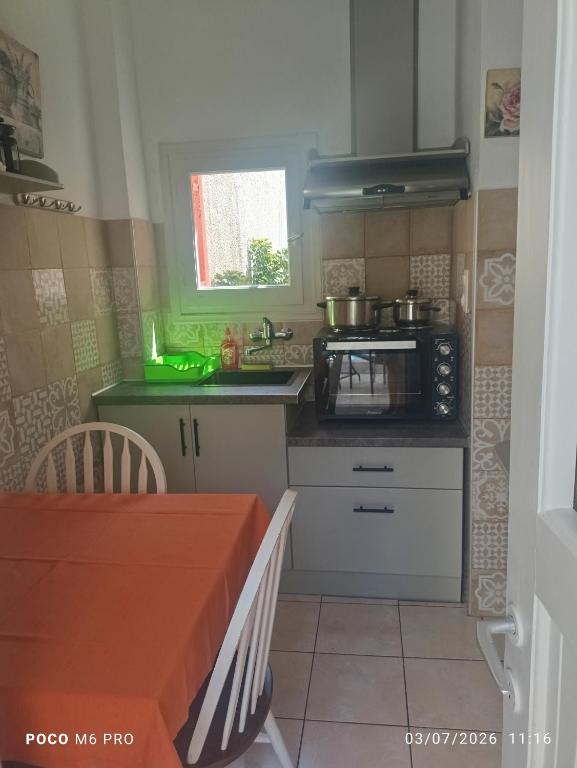 a small kitchen with a stove and a sink at Pension Galazios Kolpos in Patitiri