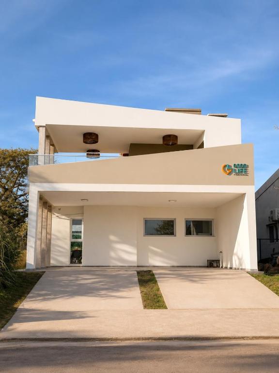 a white house with a driveway at Complejo GOOD LIFE in Miramar