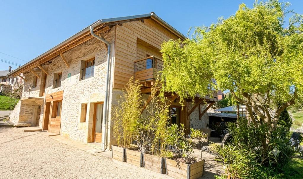 a house with a tree in front of it at Gîte Le Verger in Traize