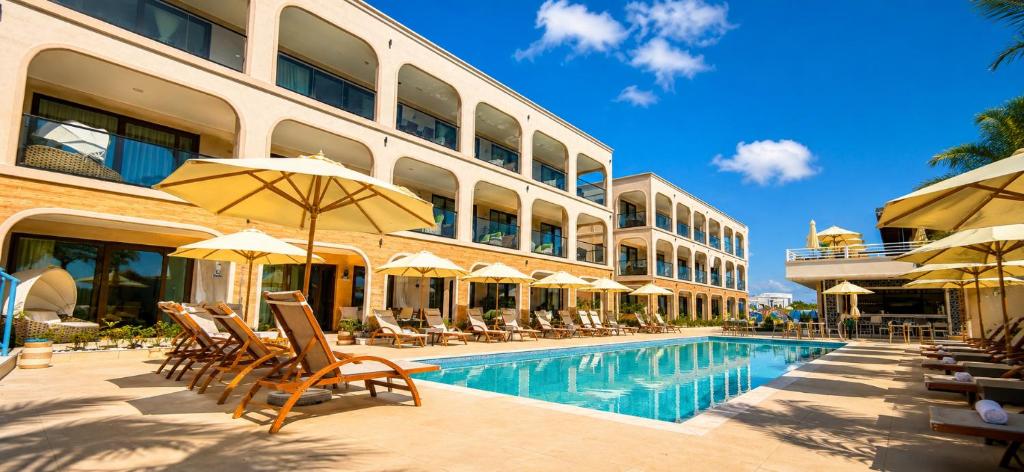 a hotel with a swimming pool with chairs and umbrellas at Bluezone Club Residences by A'ila Resorts in Rodney Bay Village