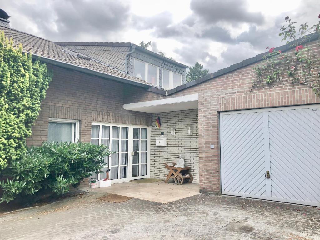 a brick house with a white garage door at Only Lady Kaarst in Kaarst