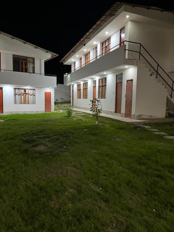 a building with a grass yard in front of it at Las Lomas Hotel in Caraz