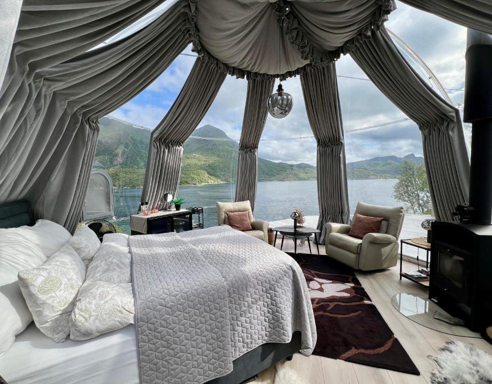 a bedroom with a bed and a large window at Lofoten Glamping Dome in Myrland