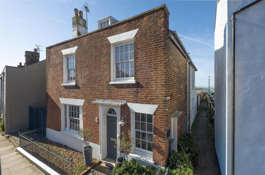 a red brick house with white windows and a door at Copeland House 4 Island Wall in Whitstable