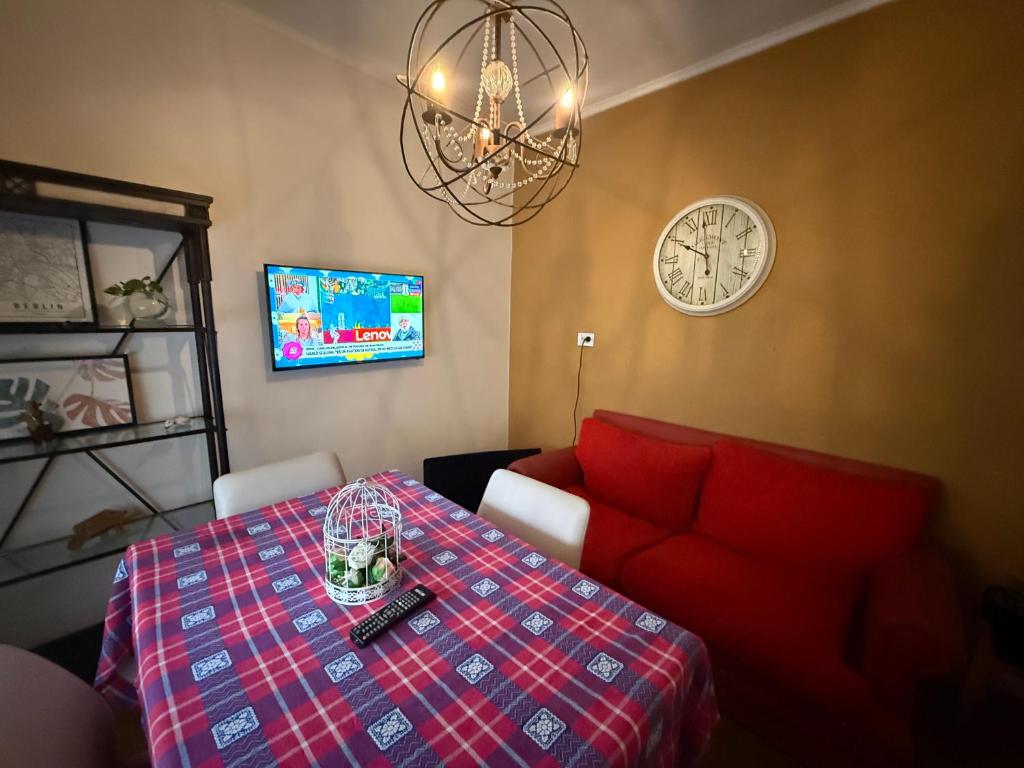 a dining room with a table and a couch and a clock at casa Muñiz in Muñiz