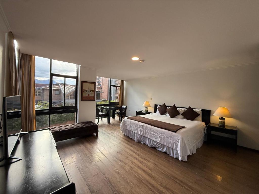 a bedroom with a large bed and a large window at Hotel NASS Pinar del Lago in Cuenca