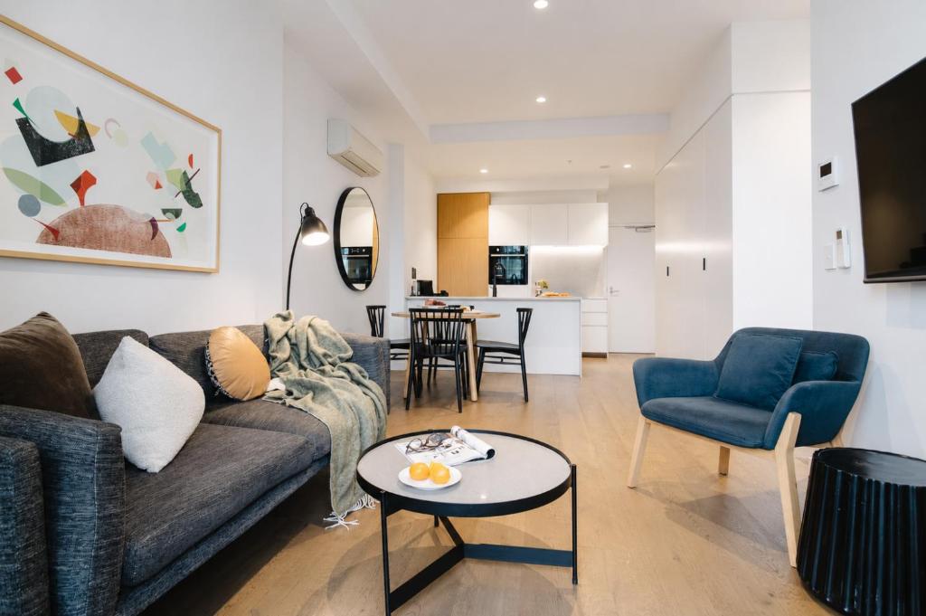 a living room with a couch and a table at Punthill Ivanhoe in Melbourne