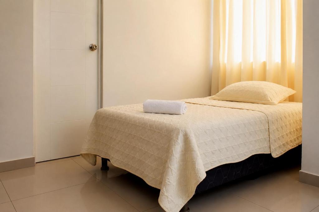 a bedroom with a bed with a towel on it at Hotel Inkayacu in Paracas