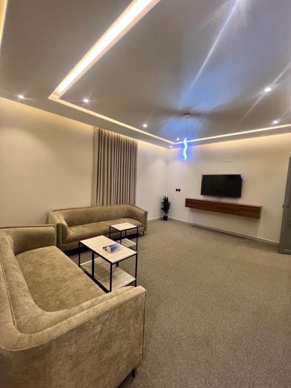a living room with a couch and a flat screen tv at شقق فاخرة in Mahlal