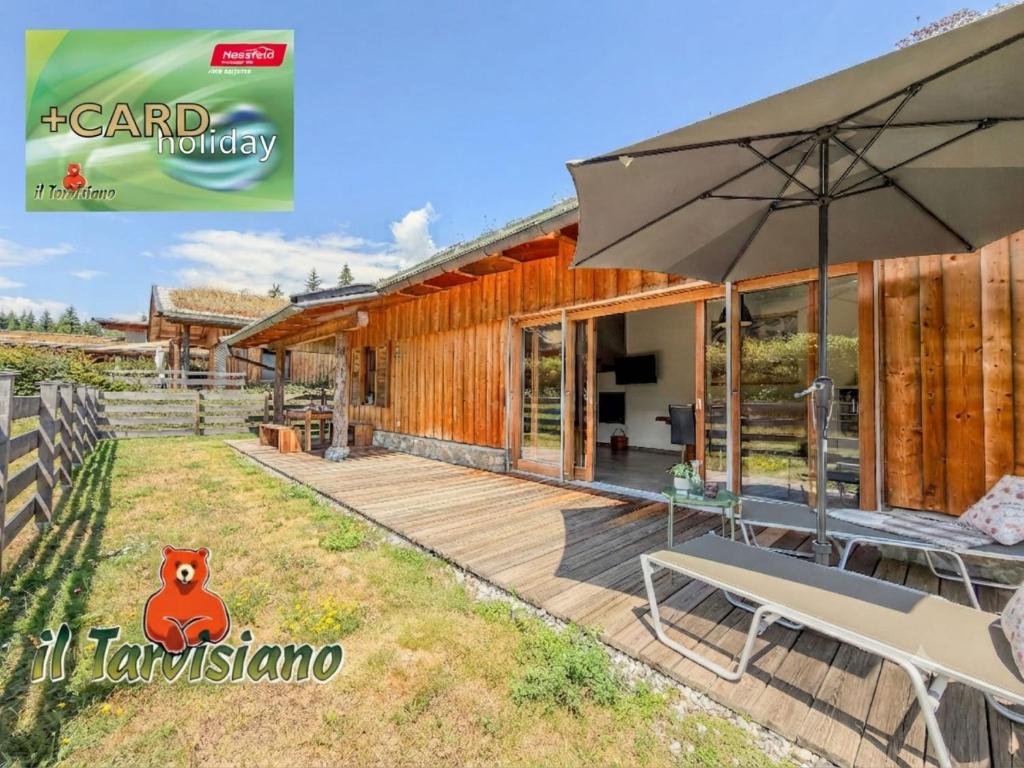 a house with a patio and an umbrella at Bellone 52 in Lake Pressegg