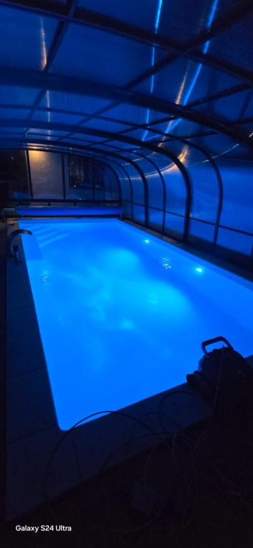 a swimming pool with blue lighting in a dark room at Paradise Vibe Balaton in Balatonkenese