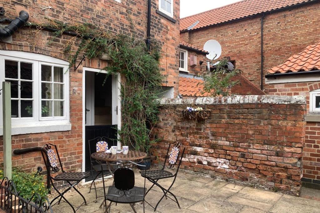 a patio with chairs and a table in front of a brick building at 2 Bed in Newark oc-o36894 in Newark-on-Trent