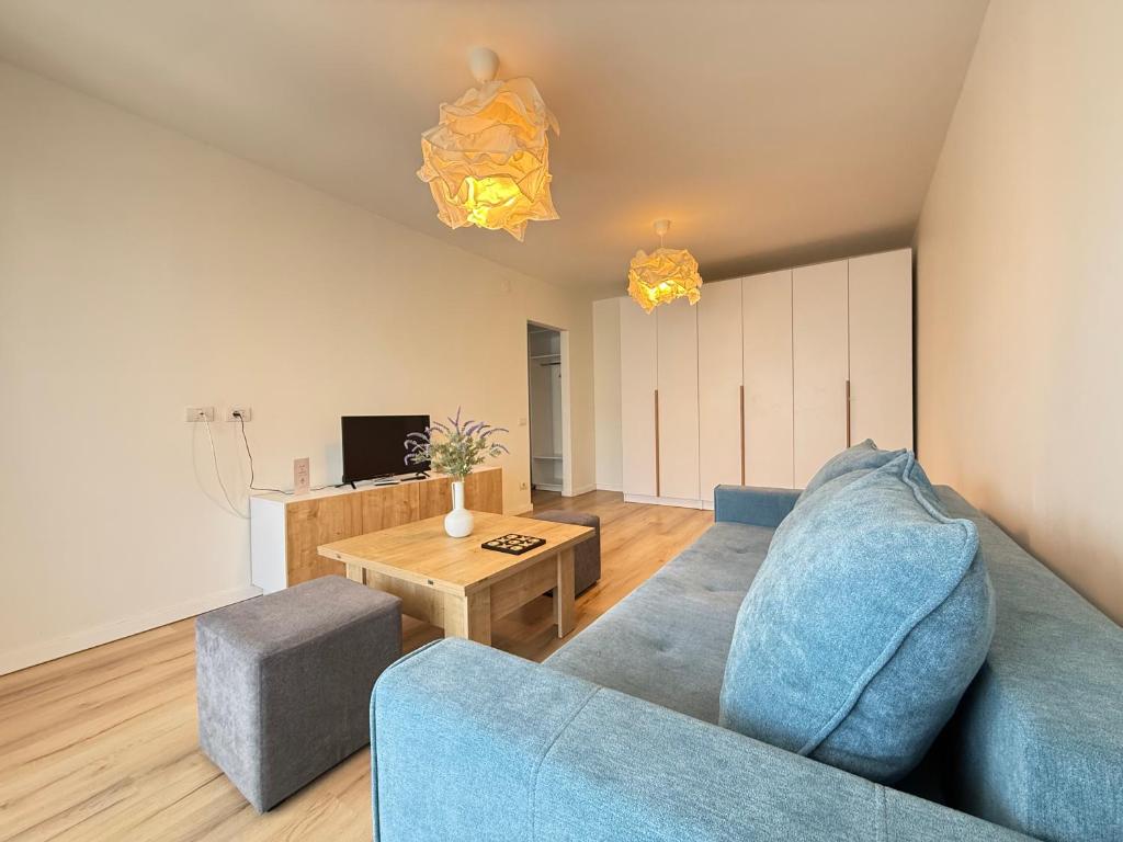 a living room with a blue couch and a table at ThePlaceToBe2 in Brăila