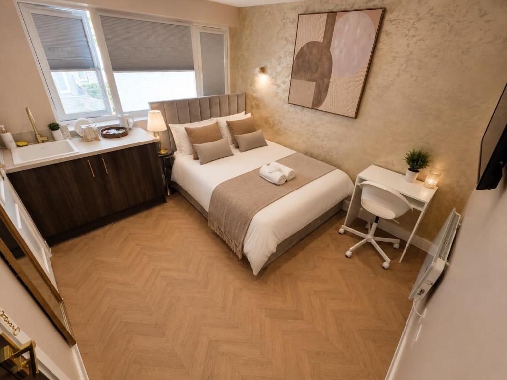 a bedroom with a bed and a desk and a chair at Hayes Studios near Heathrow in Northolt