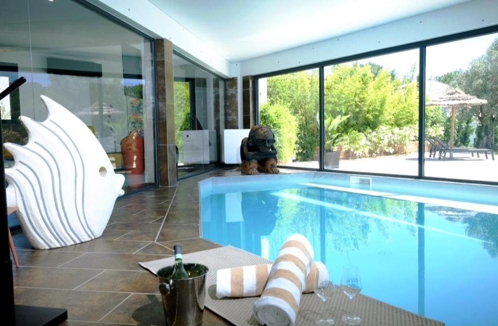 a house with a swimming pool with glass walls at Bien plus qu un séjour Une expérience à vivre in Mondragon