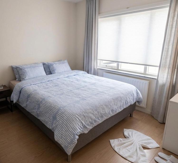 a bedroom with a large bed with a window at Negenendertigtwintig-Lommel in Lommel