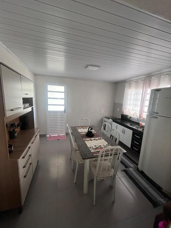 a kitchen with a table and chairs and a refrigerator at Casa proxima ABQM in Araçatuba