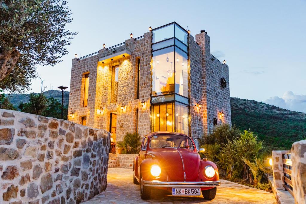 an old red car parked in front of a building at Countryside in Ulcinj